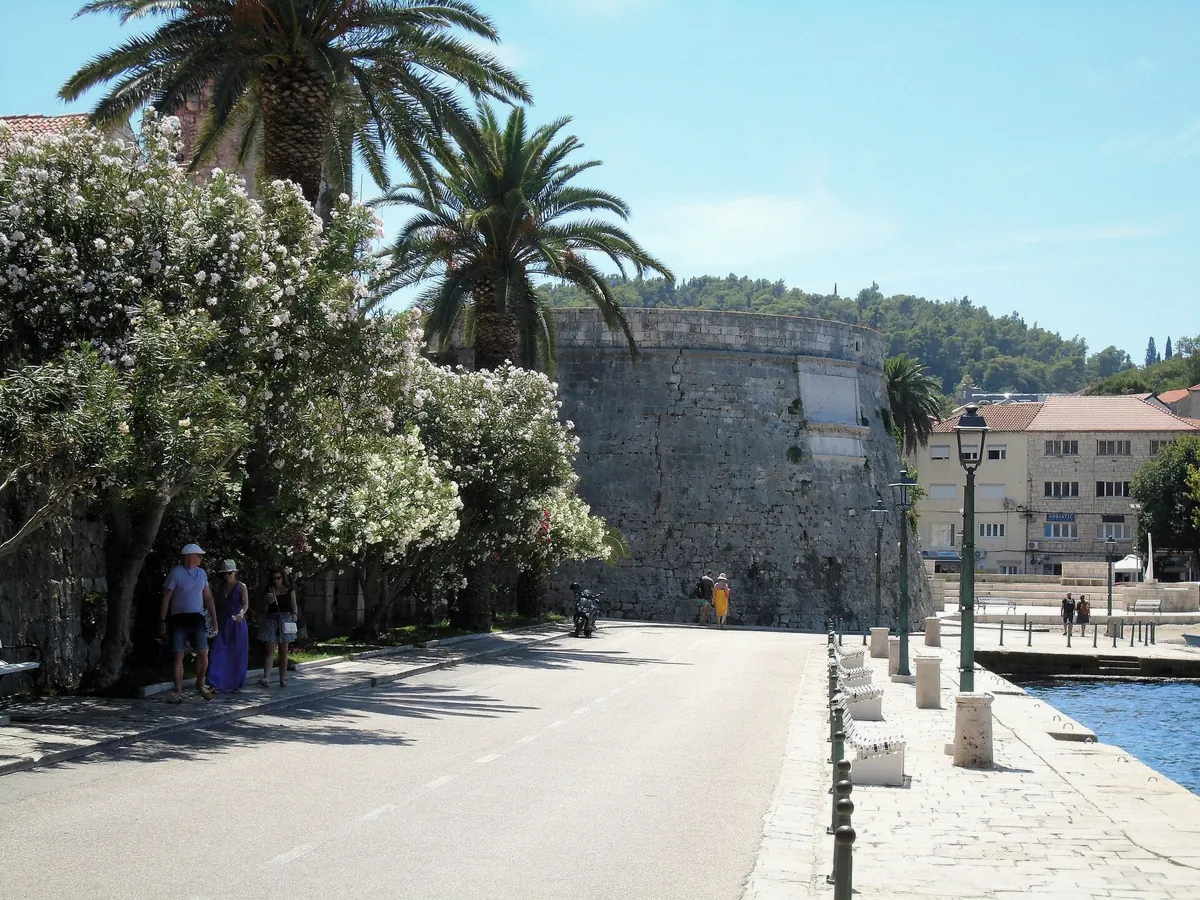 Riva promenade under the fortress walls of Korcula Town in Croatia where visitors walk everywhere
